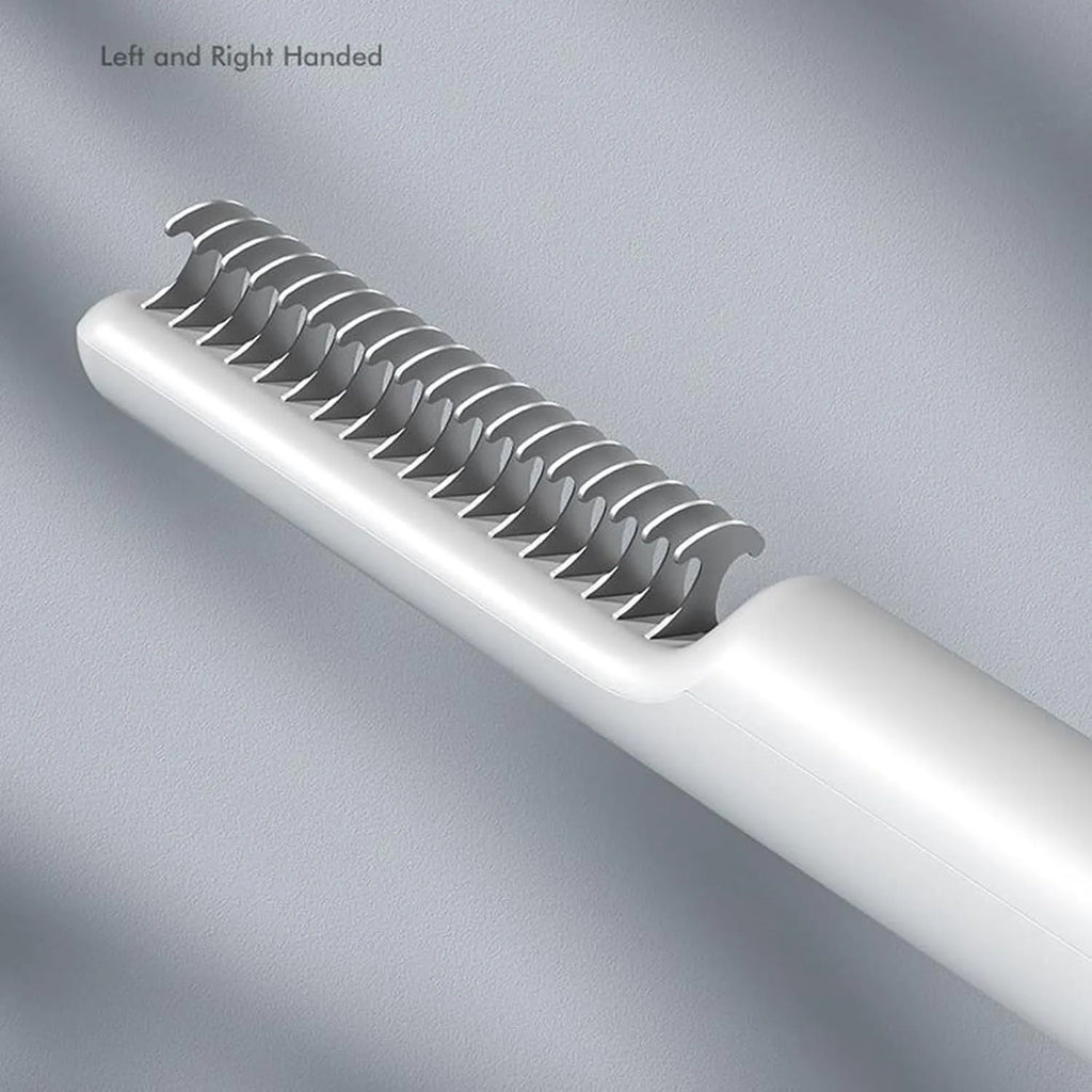 Pink and white stainless steel dog dematting comb with rake teeth on a wooden table.