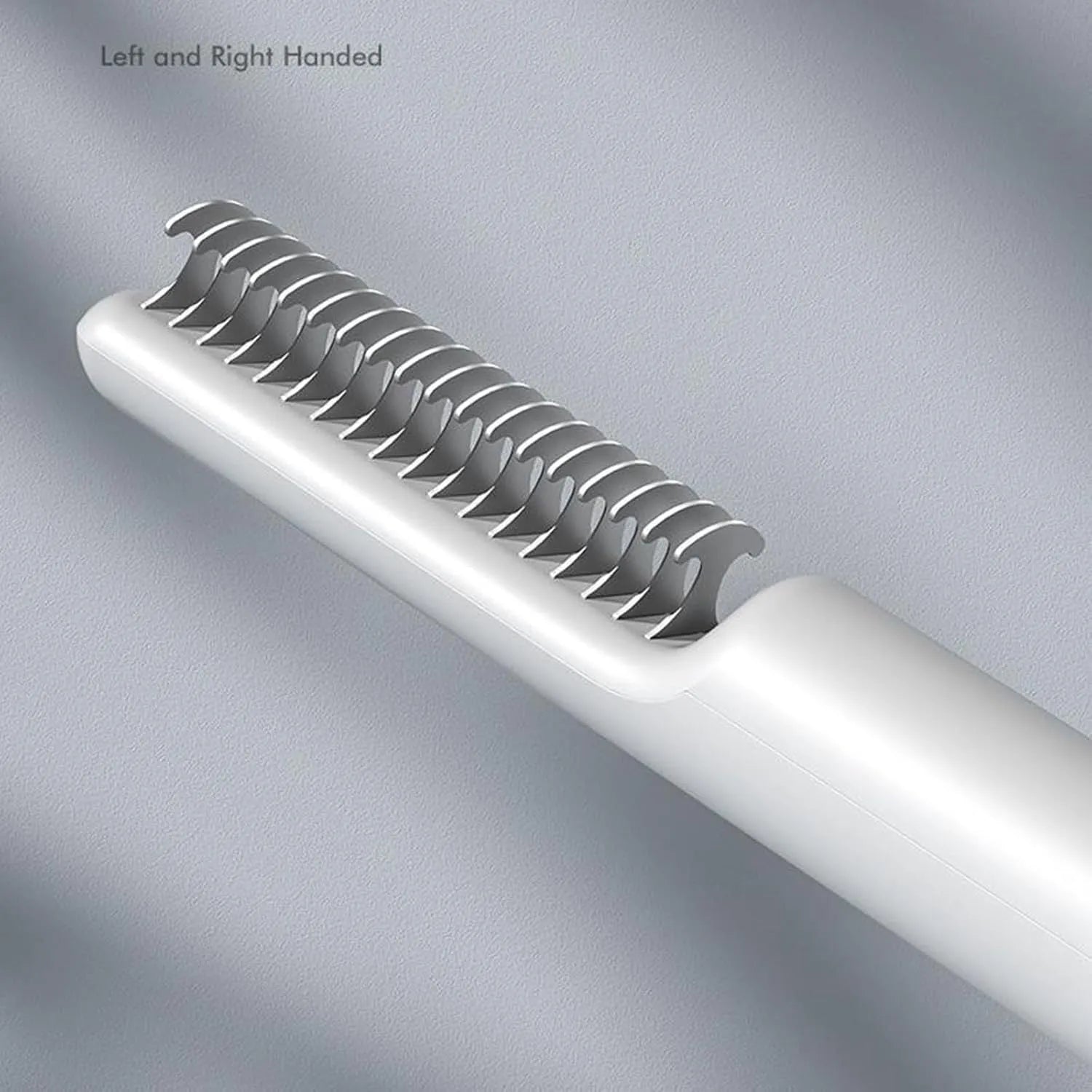 Pink and white stainless steel dog dematting comb with rake teeth on a wooden table.