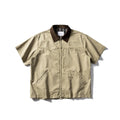 A khaki-coloured, short-sleeved overalls shirt with a loose cardigan style on a hanger.