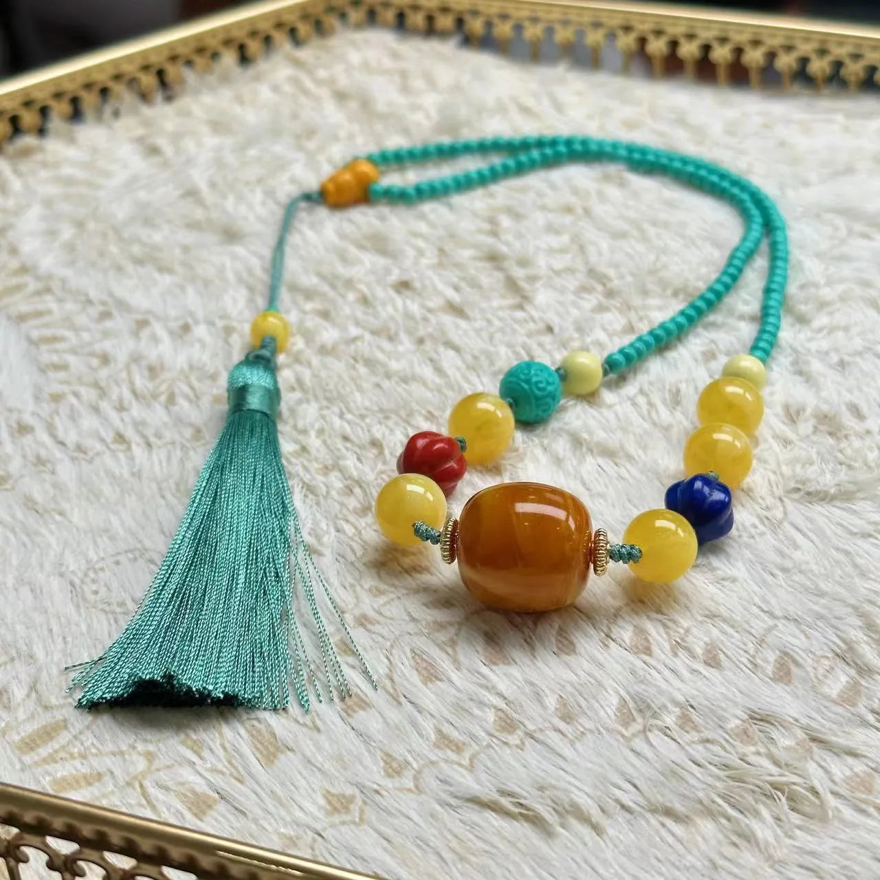 Close-up of a hand-woven turquoise mesh flower pendant on a ball bead necklace, adjustable from 71cm to 80cm.