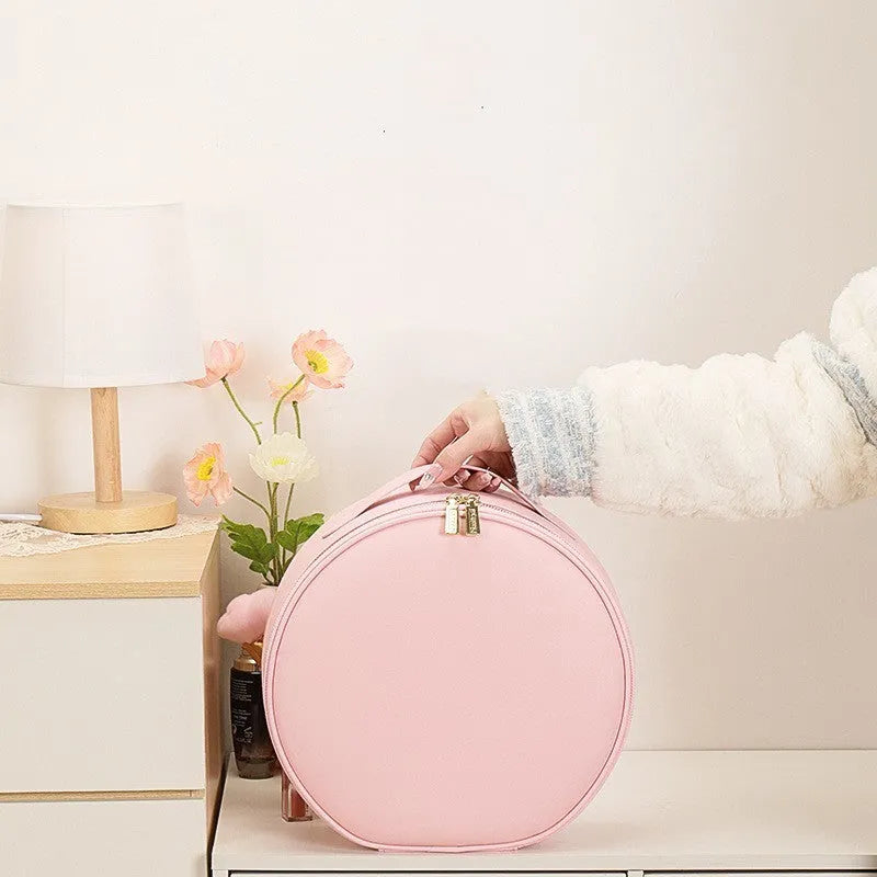 Round pink PU leather makeup bag with built-in LED illuminated mirror and internal cosmetic partitions open.