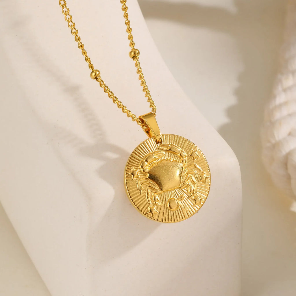 Stainless steel zodiac constellation necklace with round pendant showing embossed star signs on cross chain
