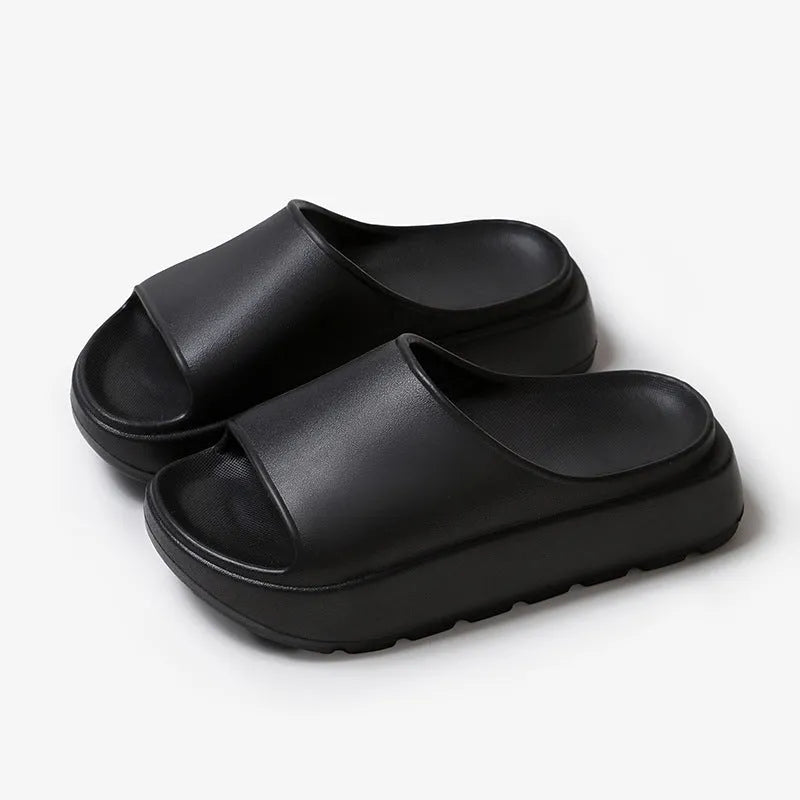 Women's beige fish mouth style EVA slippers with a thick sole, shown on a sandy beach background.