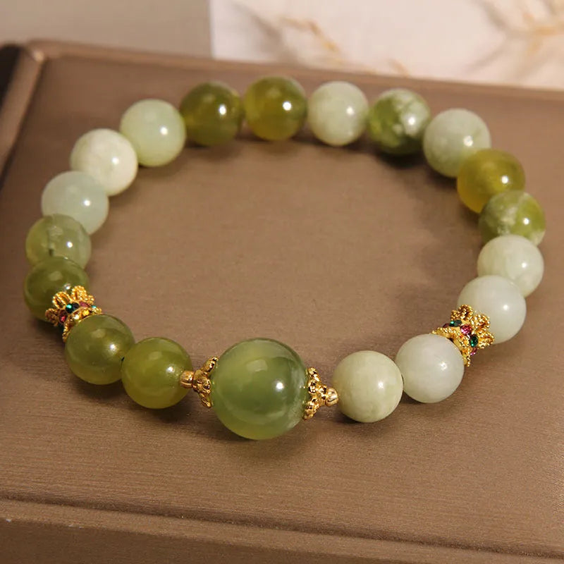 Xiuyan jade green women's bracelet with sweet Mori style design on a wrist.
