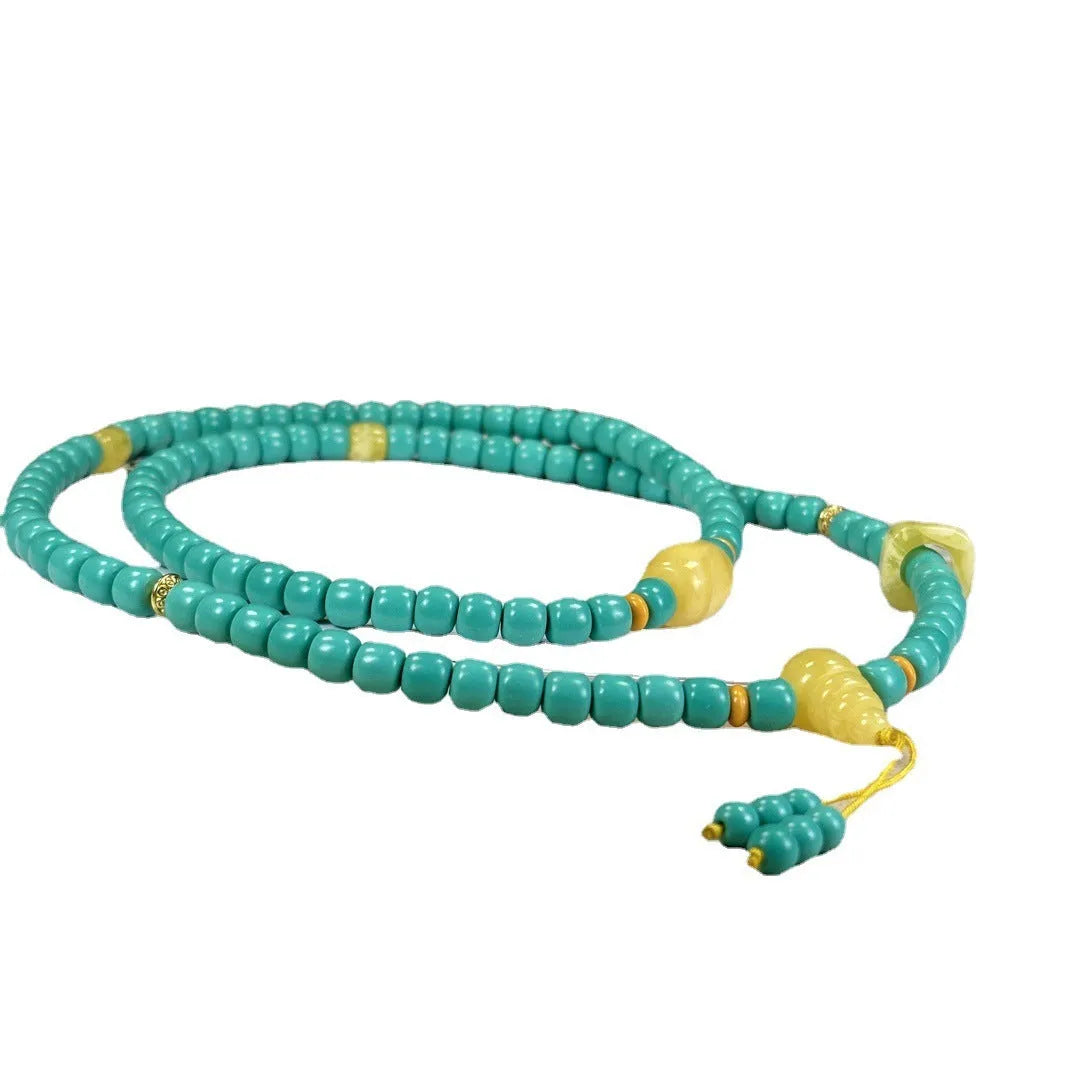 Close-up of a hand-woven turquoise mesh flower pendant on a ball bead necklace, adjustable from 71cm to 80cm.