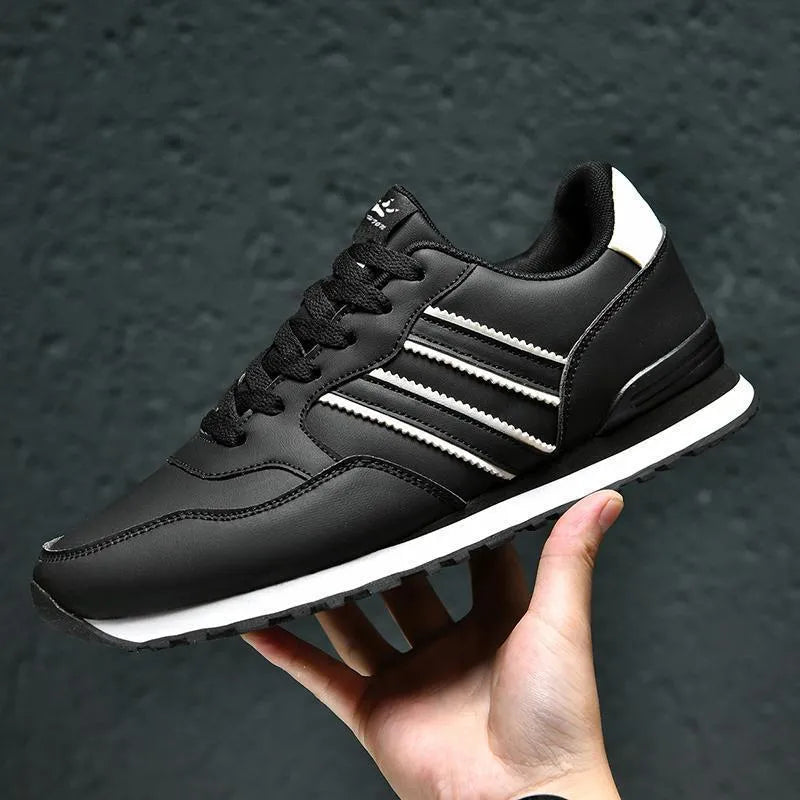 Men's black leather casual running shoes with carved wing pattern and a high heel.