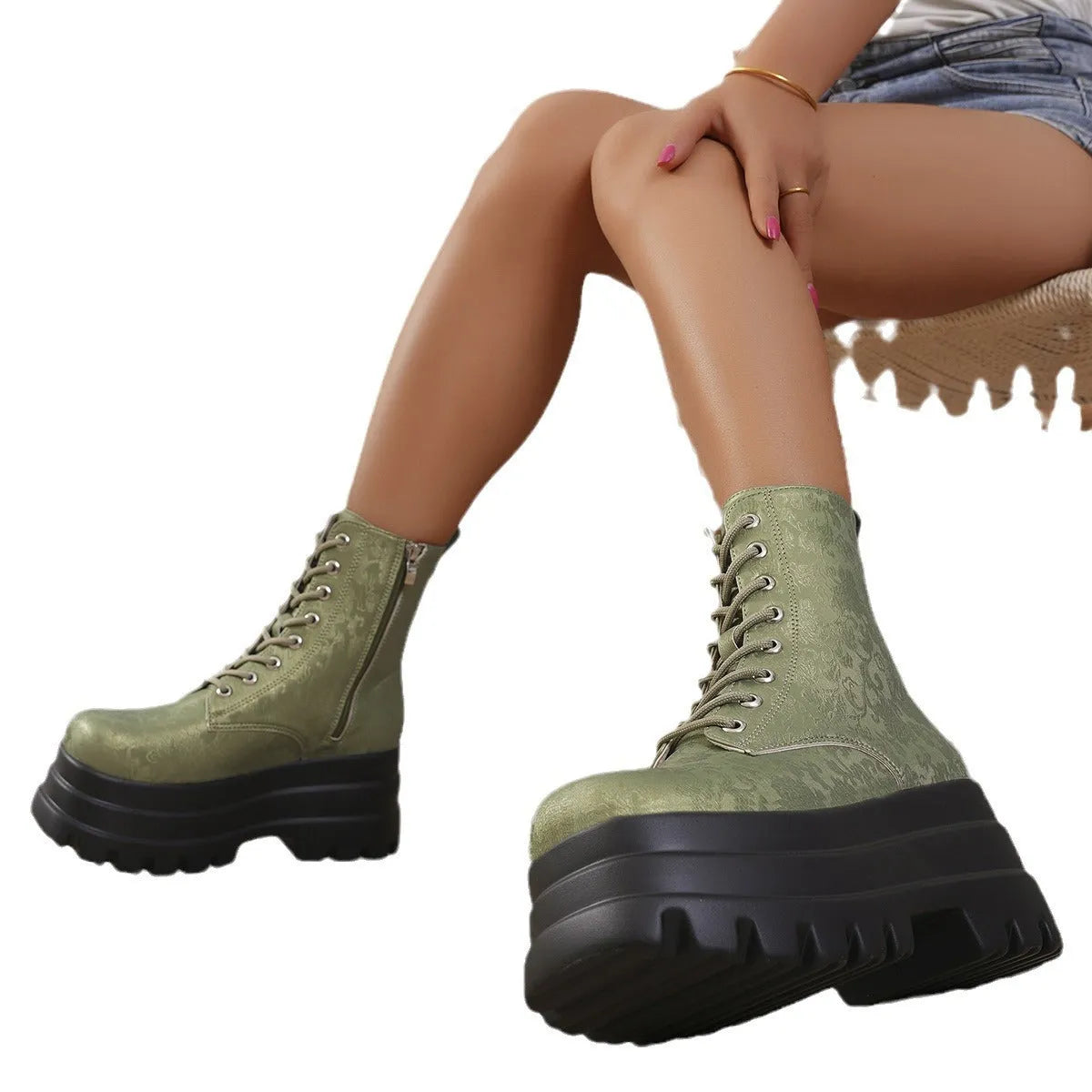 Women's black platform Martin boots with patchwork detail and side zip on a white background.