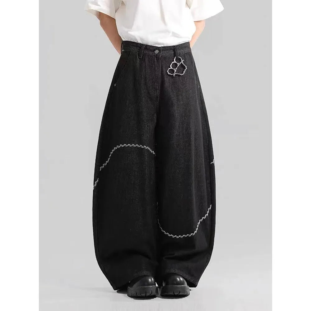 Black straight-leg denim trousers laid flat, showing zip fly and mid-waist design.