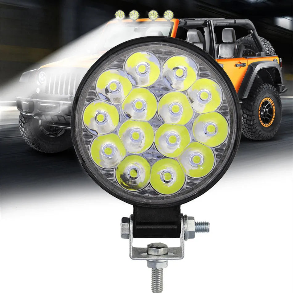 Compact round aluminium LED work light with white light, suitable for vehicle mounting.