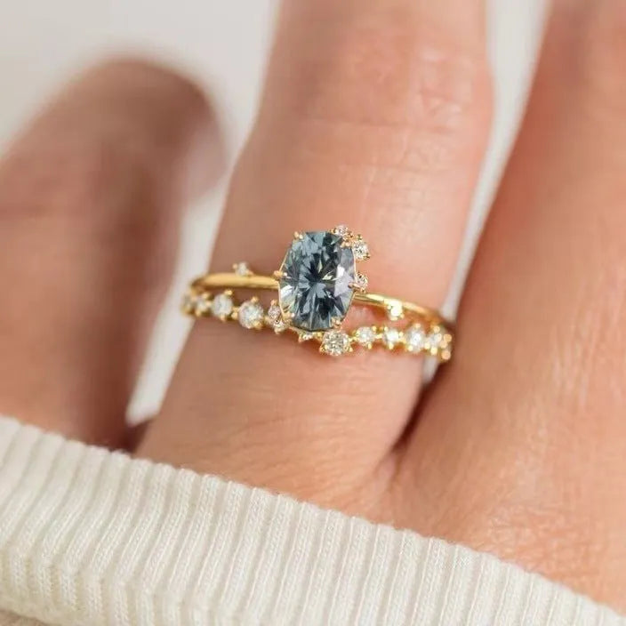 Gold plated women's flower-shaped ring with a green zircon stone, shown in a pair.