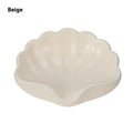 White shell-shaped plastic soap dish for bathroom countertop.