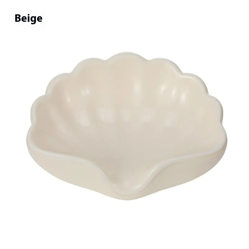 White shell-shaped plastic soap dish for bathroom countertop.
