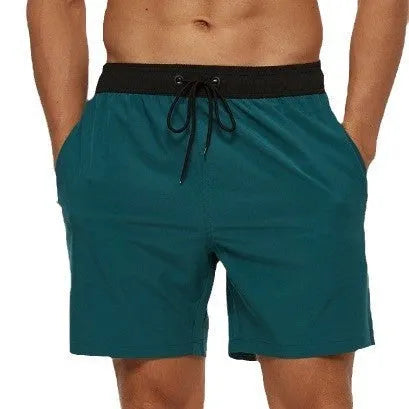 Men's blue stitching waist training shorts with zipper pockets and a drawstring, laid flat.