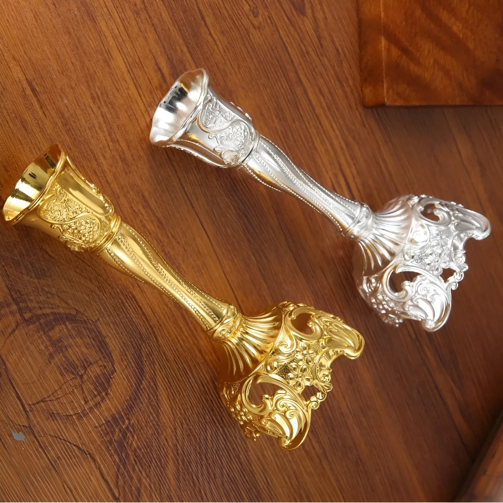 Small metal retro candlestick ornament in gold finish on a table