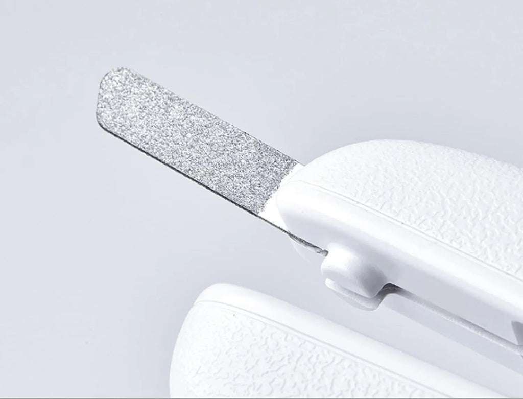 White pet nail clipper with LED light and transparent anti-splash guard on a blue background.