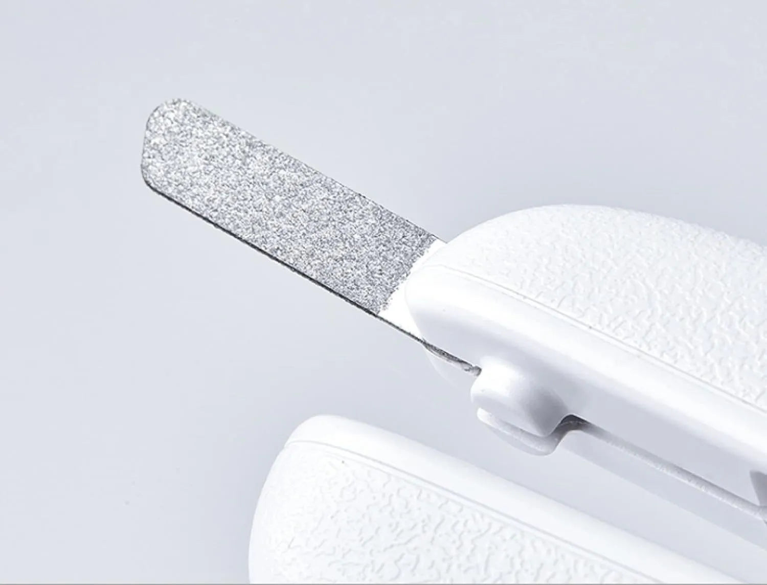 White pet nail clipper with LED light and transparent anti-splash guard on a blue background.