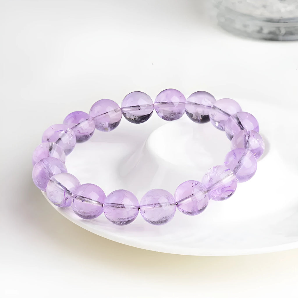Lavender round amethyst crystal bead bracelet with water ripple design on a wrist.