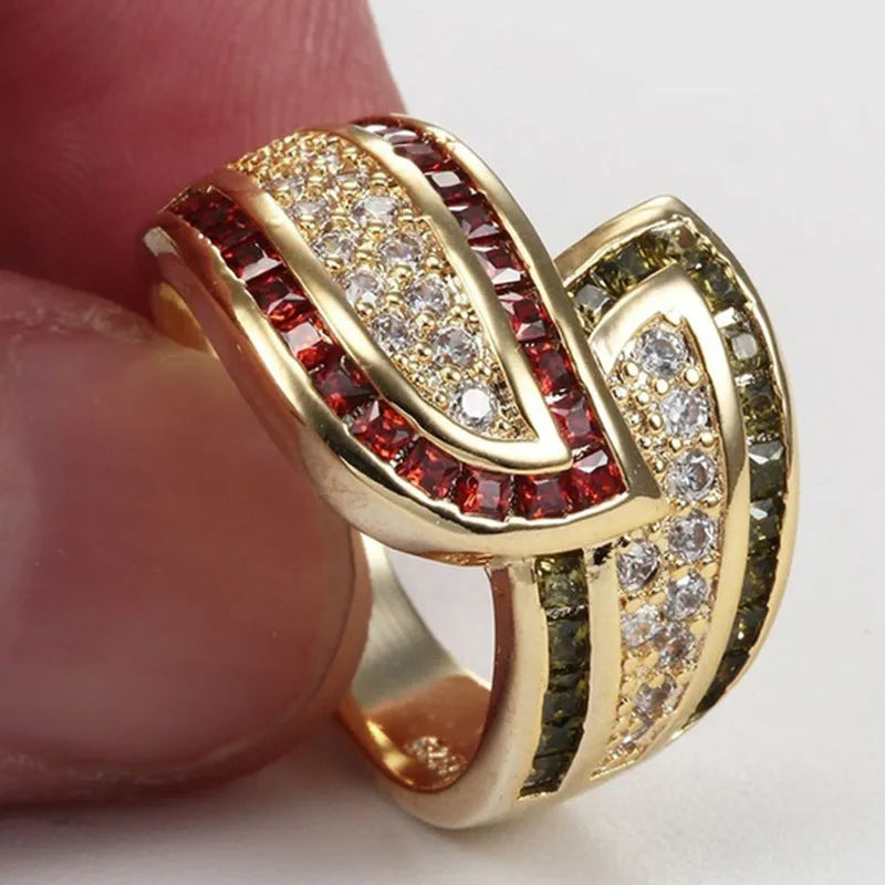 Gold women's ring with green peridot stone on finger, showing metallic finish and stone detail