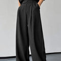Men's black vertical striped pleated casual trousers showing elastic fabric detail