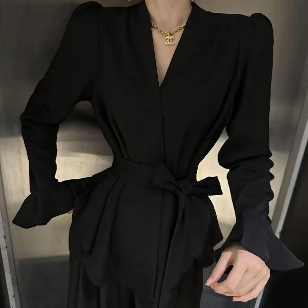 Women's black French-style shirt with long bell sleeves, an irregular collar, and a tied front detail.