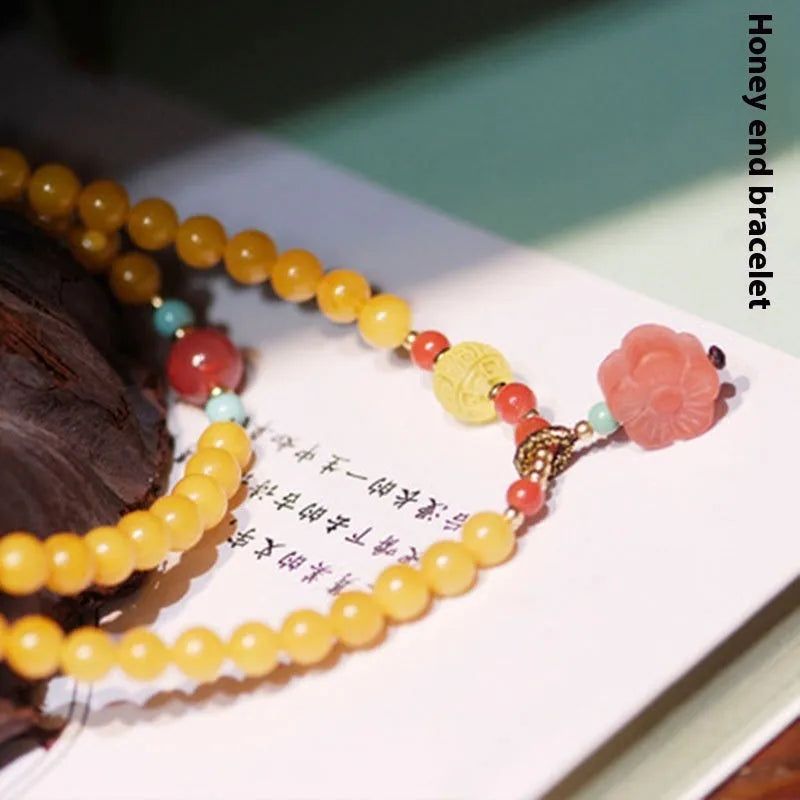 Yellow chicken grease beeswax amber bracelet with 5mm round beads and animal zodiac design.