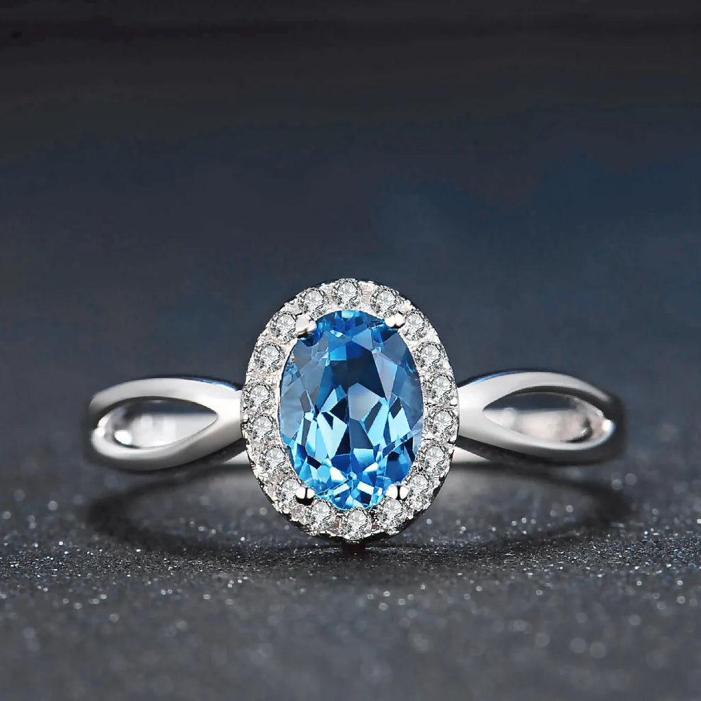 Four-piece sterling silver jewellery set with blue topaz: geometric earrings, ring, pendant, and necklace.