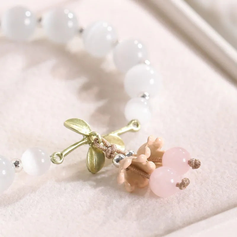 Close-up of a women's opal beaded bracelet with diamond-shaped cat's eye stones on a wrist.