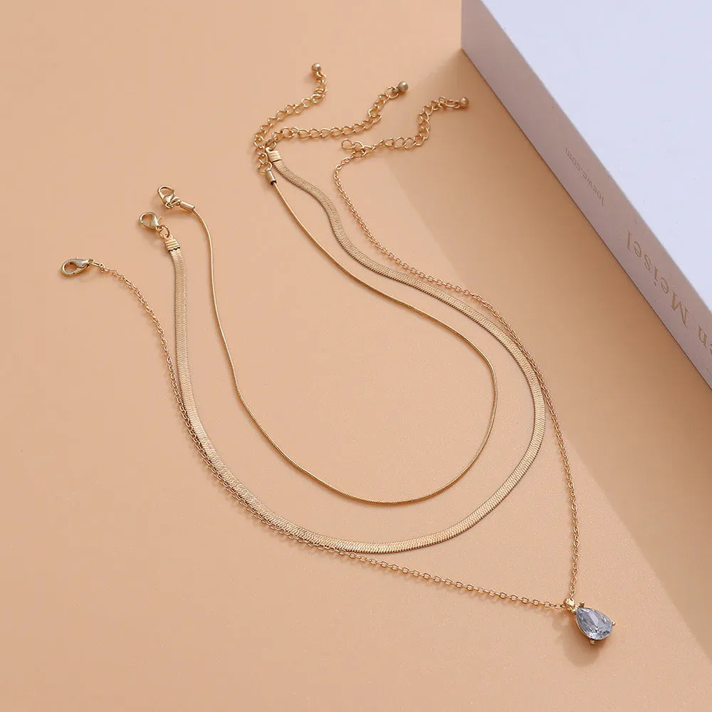 Gold and silver water drop shape alloy pendant necklace with electroplated finish on white background