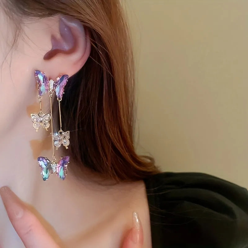 A pair of blue purple butterfly tassel earrings with silver needle crystal flowers on alloy posts.