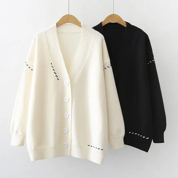 A women's loose-fit knitted cardigan coat in black, showing long sleeves and a solid colour design.