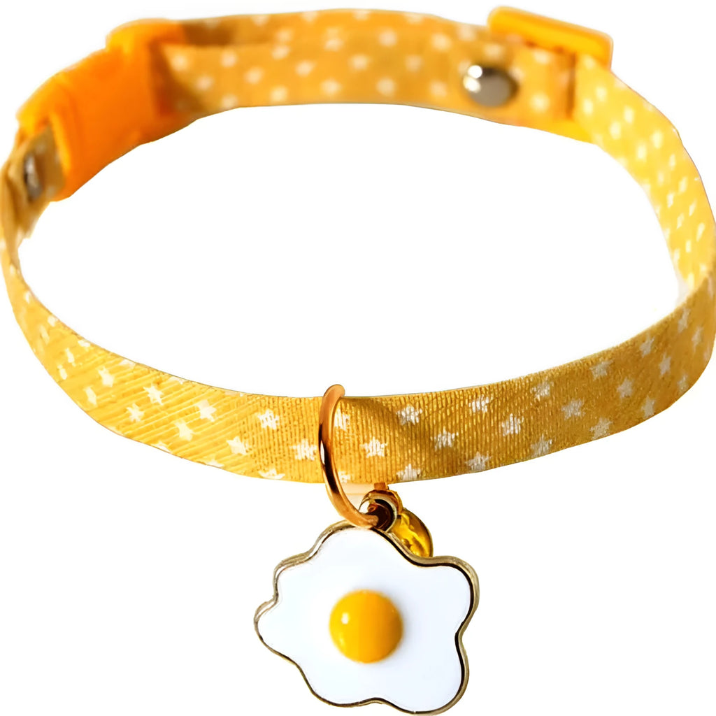 Adjustable green cat collar with a silver bell and pink bow tie on a white background.