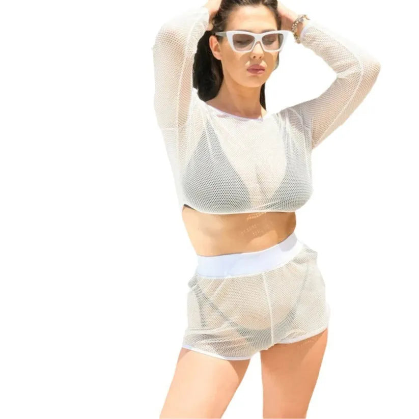 White transparent women's swimsuit bikini top and skirt set on a beach.
