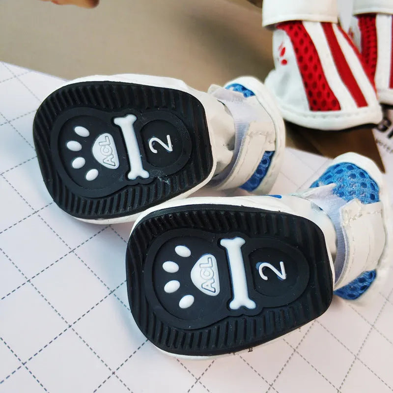 Four blue cloth dog sneakers with zipper closures arranged on a white background