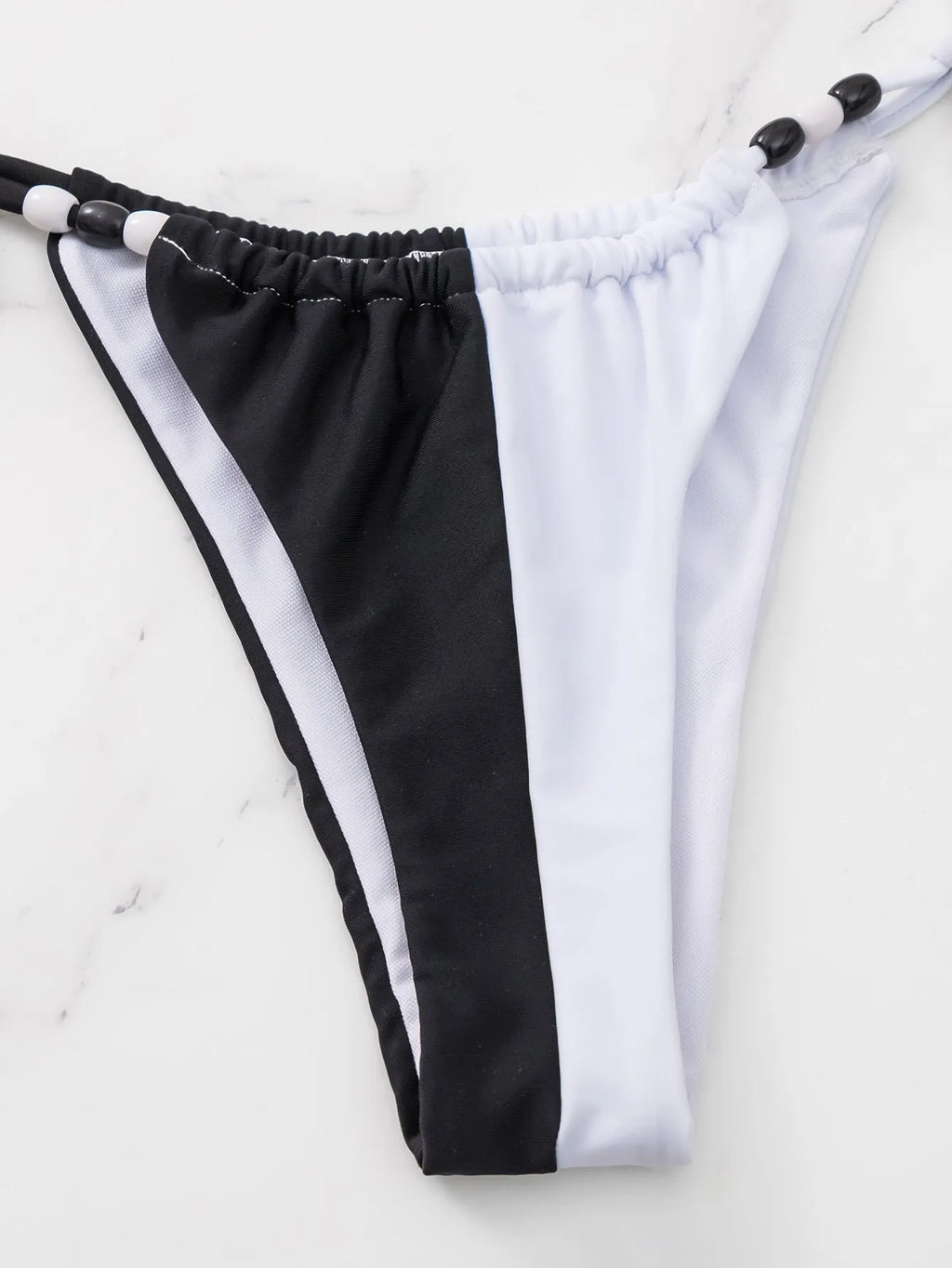 Black and white women's bikini set with lace-up front on triangle top and matching briefs.