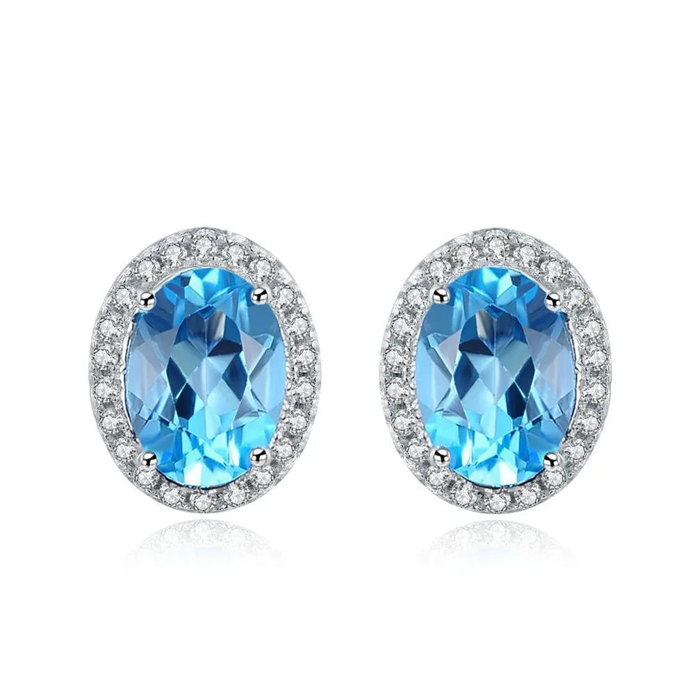 Four-piece sterling silver jewellery set with blue topaz: geometric earrings, ring, pendant, and necklace.