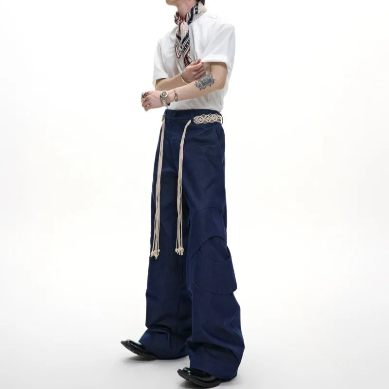 Man's dark blue straight-leg cotton trousers with belt stitching and zipper details on a loose fit.