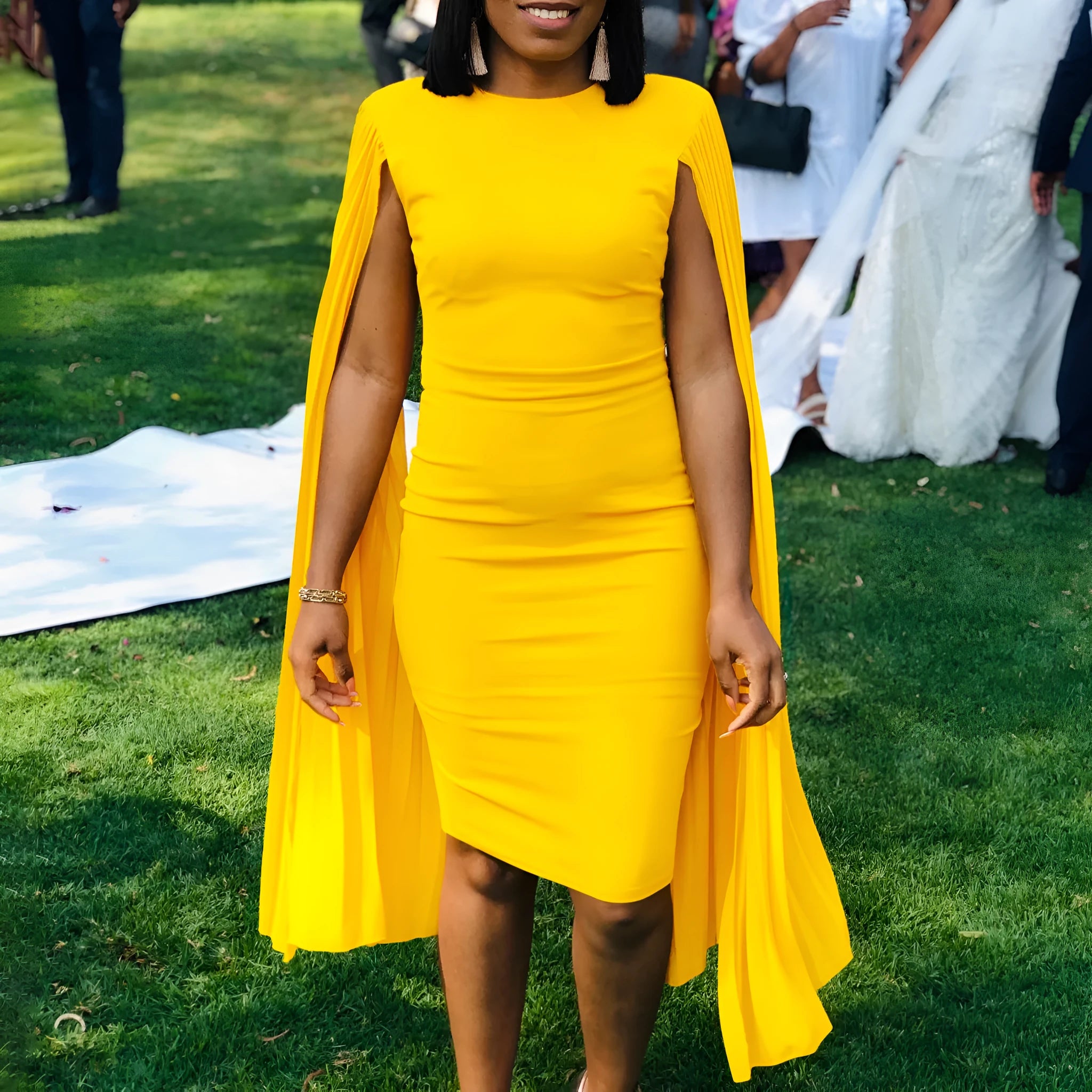 A woman wearing a long sleeve, high-waisted pleated evening gown in a formal setting.