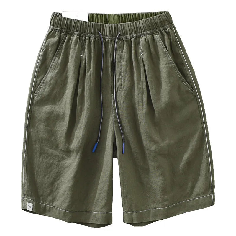 Men's loose fit linen shorts in green on a neutral background