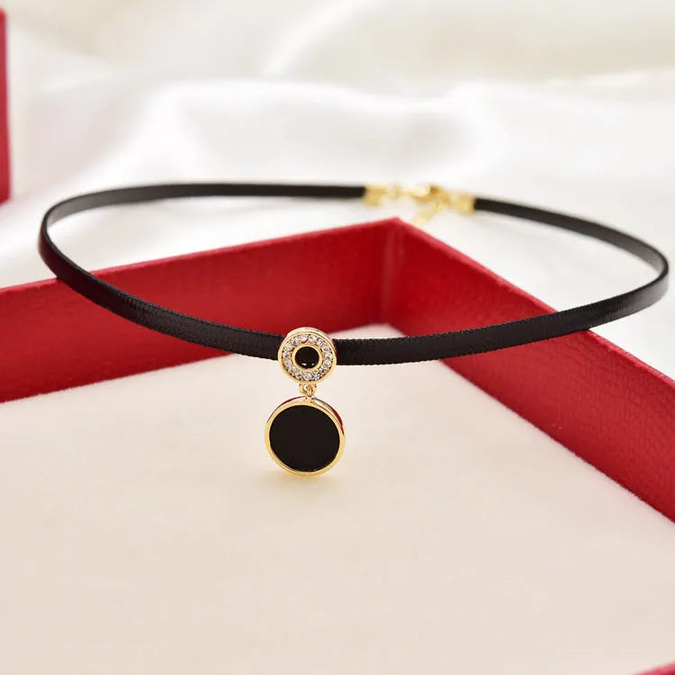 Women's short black clavicle necklace with round gold alloy pendant and leather rope chain on display