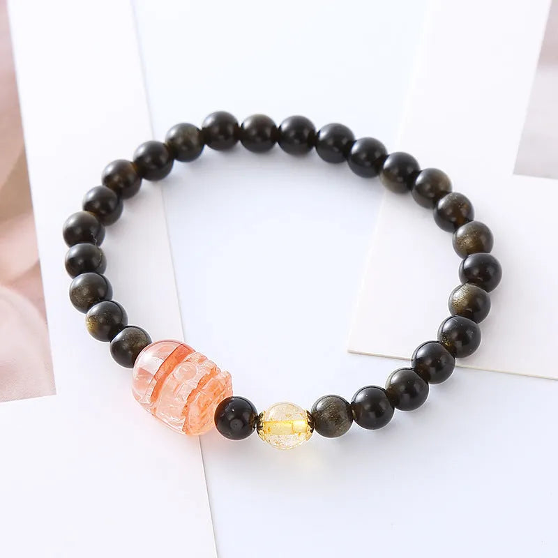 Handcrafted natural obsidian Pi Xiu bracelet in gold obsidian and red flower colours on wrist