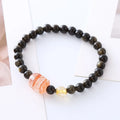 Handcrafted natural obsidian Pi Xiu bracelet in gold obsidian and red flower colours on wrist