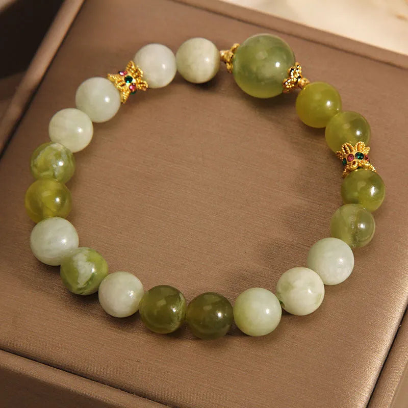Xiuyan jade green women's bracelet with sweet Mori style design on a wrist.
