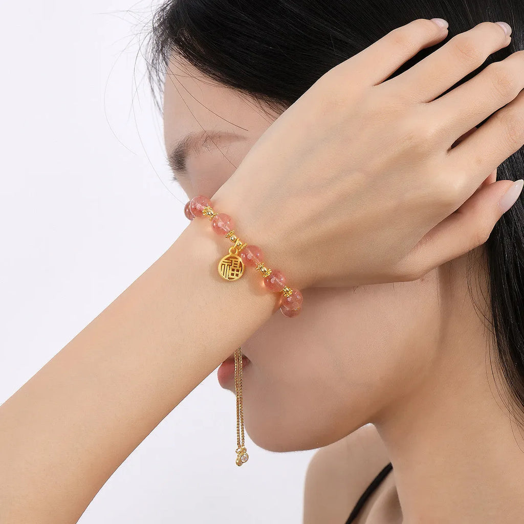 Women's strawberry quartz crystal bracelet with electroplated fu character charm and geometric design