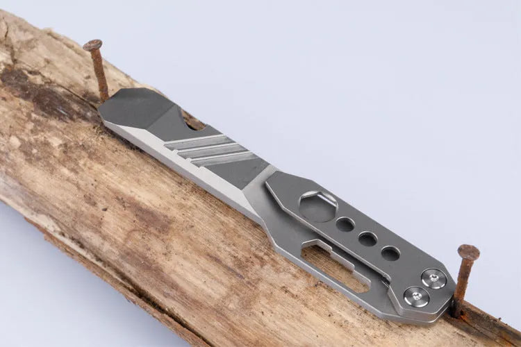 Titanium alloy multi-function crowbar tool with screwdriver tip and bottle opener in stone wash finish.