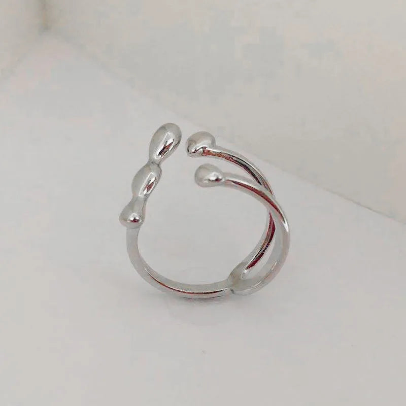 Adjustable brass ring with sphere design in gold or silver plating.
