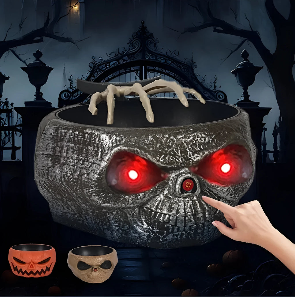 Plastic Halloween pumpkin candy bowl with motion activated skeleton hand, glowing red eyes, in Khaki colour, on a table with candy.
