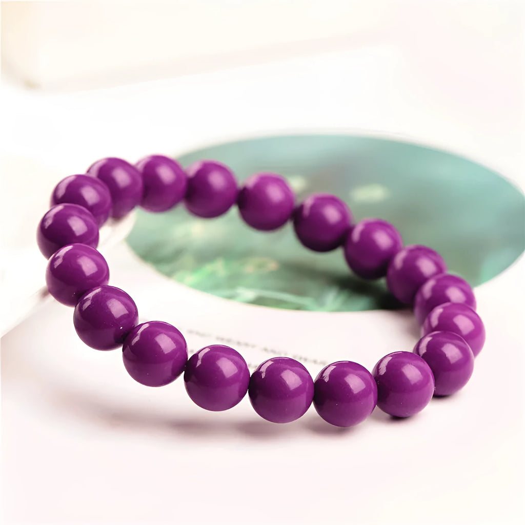 Close-up of a polished purple mica crystal bracelet with a single ring of beads on a wrist.