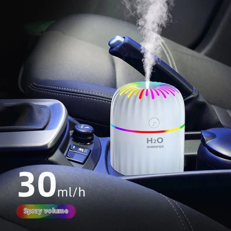 Mini animal-shaped USB humidifier and aromatherapy diffuser in green on a car dashboard.