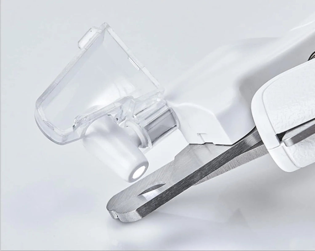 White pet nail clipper with LED light and transparent anti-splash guard on a blue background.