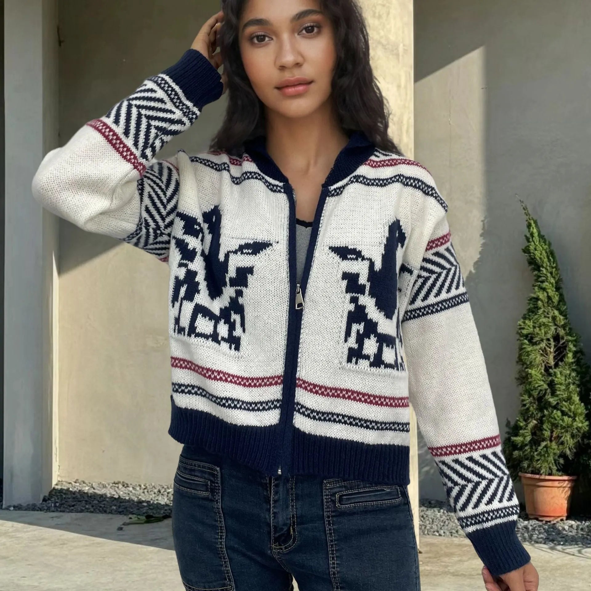 White women's zip-front cardigan with lapel collar and contrasting jacquard stripe pattern on sleeve.